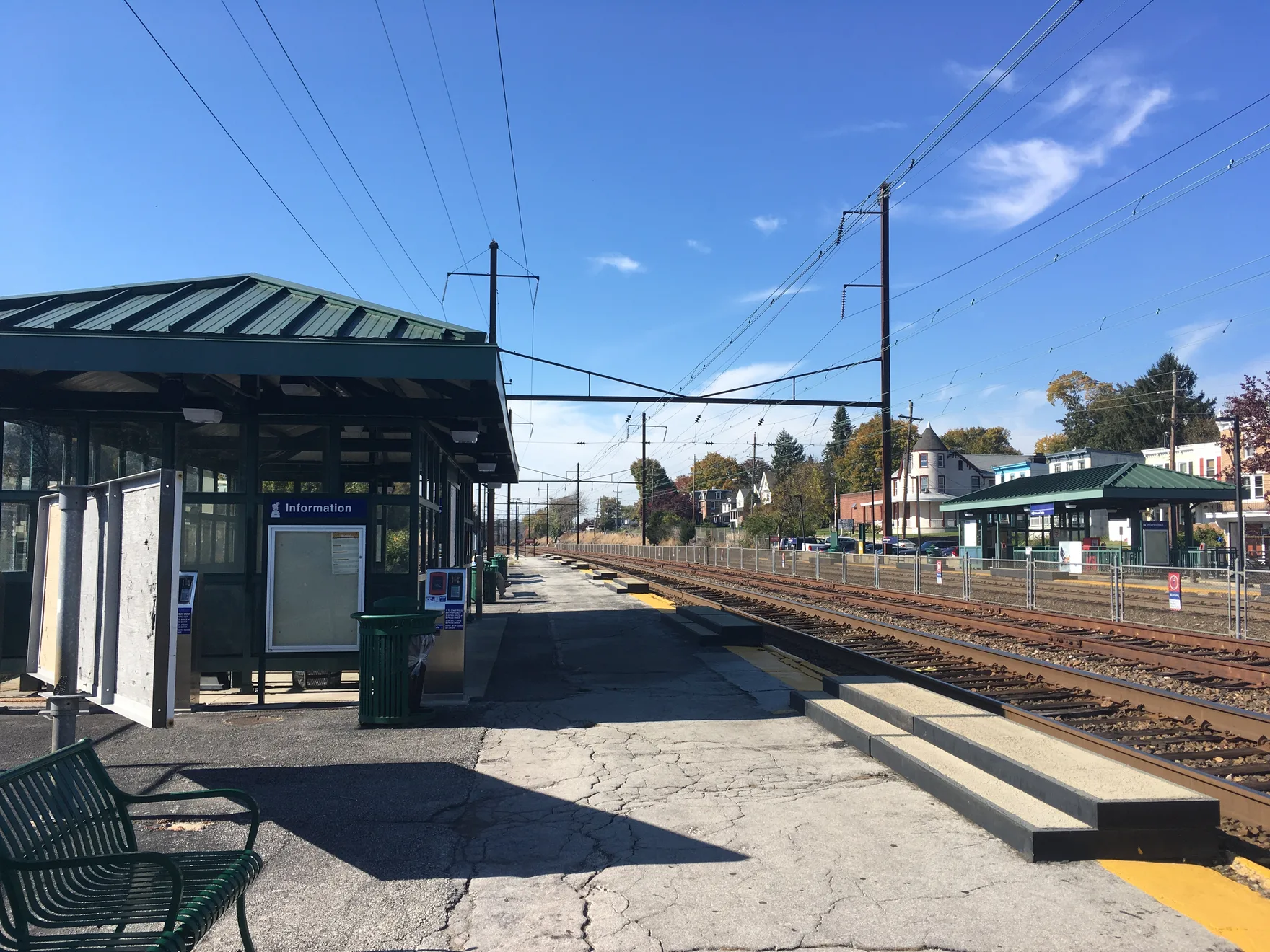 Downingtown rail station viewed from its inbound platform in November 2018, with platforms and overhead wires along the tracks.